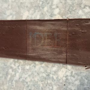 Tappo quadrato di cioccolato temperato che chiude il cubo, sigillato sui quattro lati.