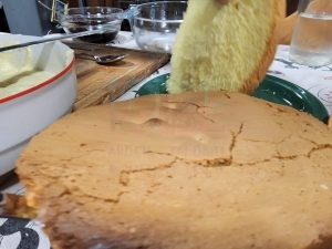 Preparazione pan di Spagna per torta, con strato di base e crema. Dolce fatto in casa, ingredienti in cucina.